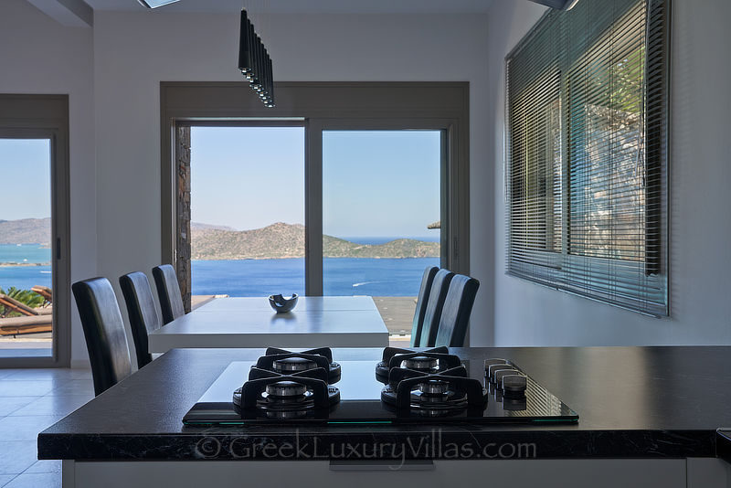 Dining with sea view from modern luxury villa with heated pool in elounda bay