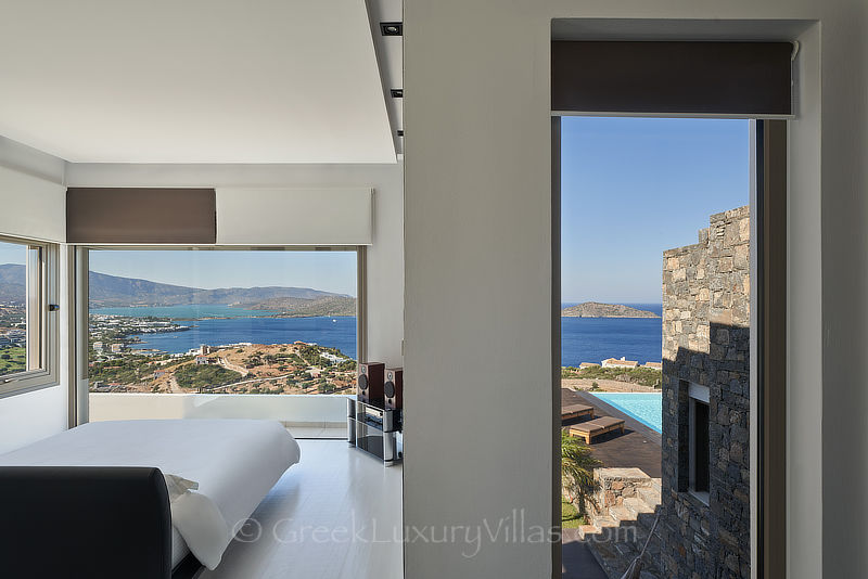 spacious master bedroom of luxury villa with pool overlooking elounda bay
