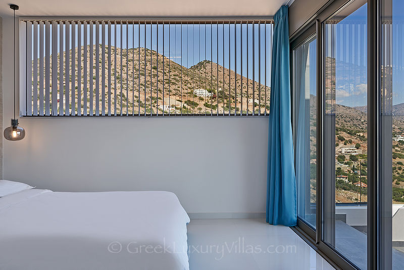 modern bedroom of luxury villa with heated pool overlooking elounda bay