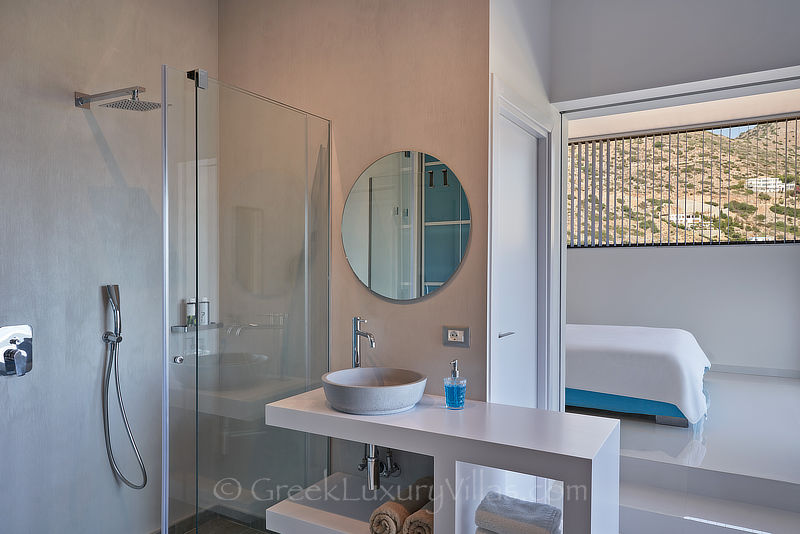 modern bedroom with en suite shower in luxury villa with heated pool in elounda