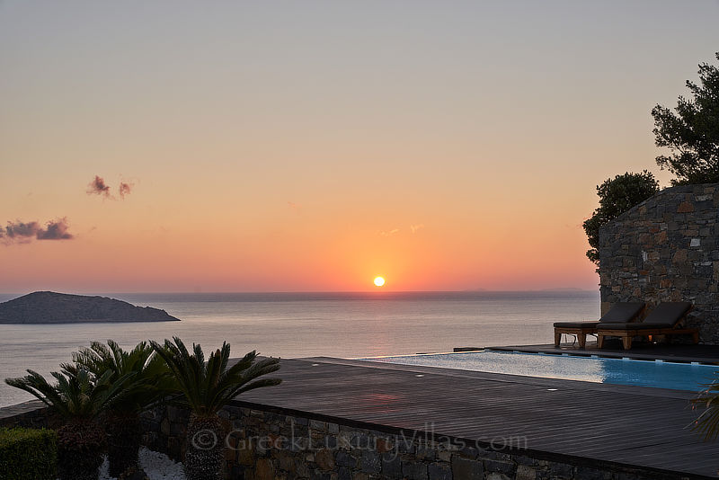sunset at modern luxury villa with heated pool overlooking elounda bay