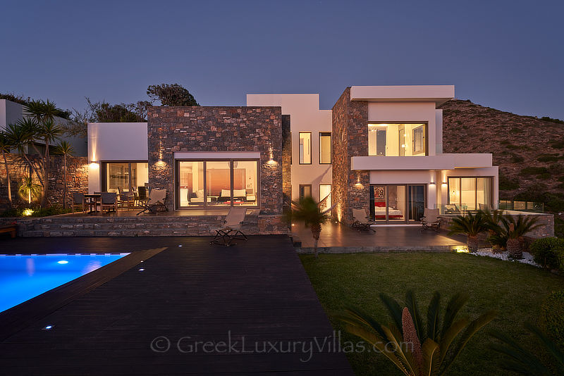 evening look of exclusive luxury villa with heated pool overlooking elounda bay