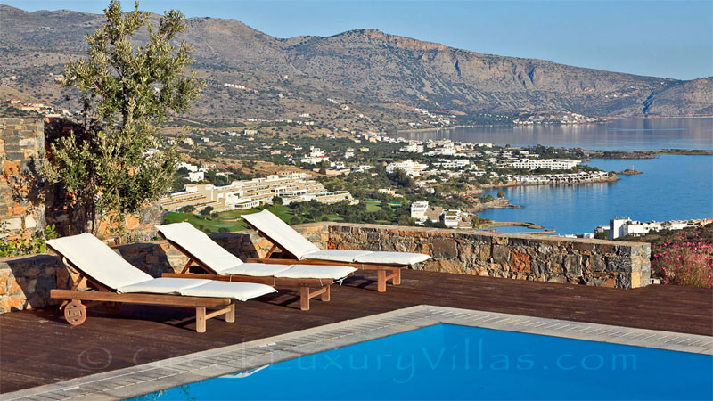 A modern luxury villa with a pool overlooking Elounda bay
