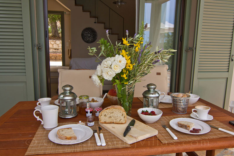 Outdoor dining area of a villa with a pool in Lefkada