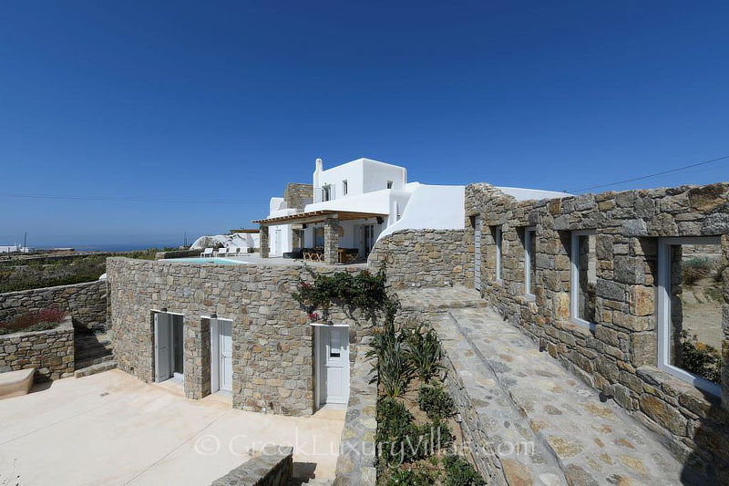 Outdoor area of villa with pool overlooking Agios Stefanos Bay