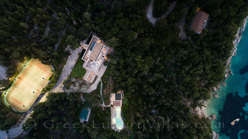 flood lit tennis at beachfront luxury villa Greece