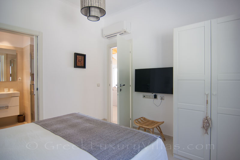 Bedroom of a modern luxury villa with a pool in Paxos