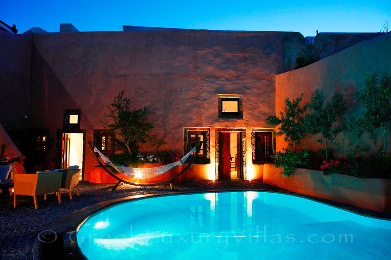 A traditional village house with a pool in Santorini at night