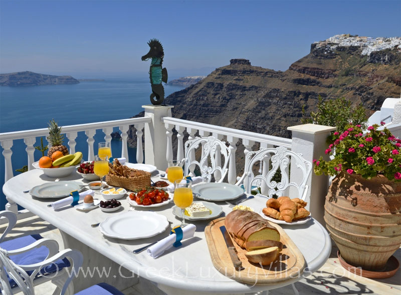 Breakfast with seaview in a large villa with a pool on the cliff in Santorini